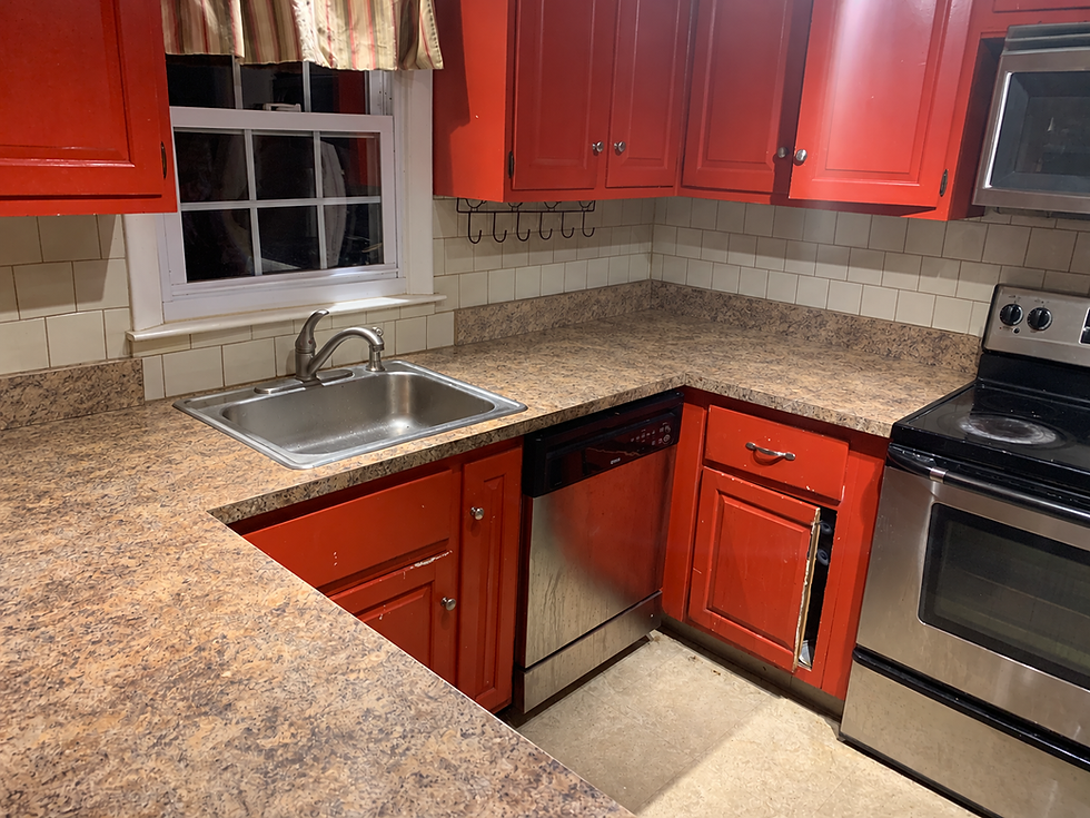 Old red cabinets, laminate countertop and original sink before the North Kingstown kitchen remodel