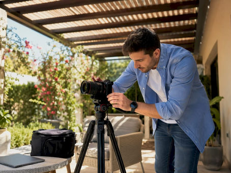 Un videomaker sta preparando la sua attrezzatura per girare le riprese all’interno di un appartamento.