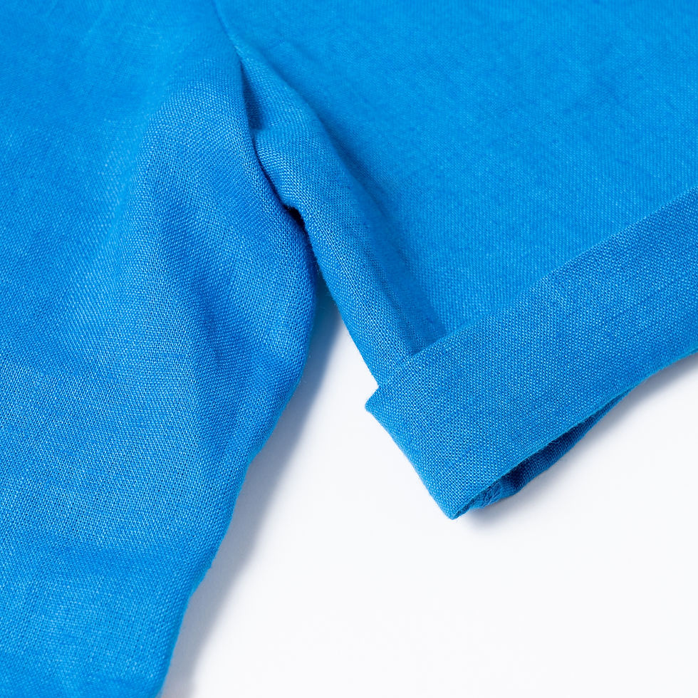 Miniaturbild: Detail von blauem Leinenshirt mit kurzen Ärmeln vor neutralen Hintergrund.