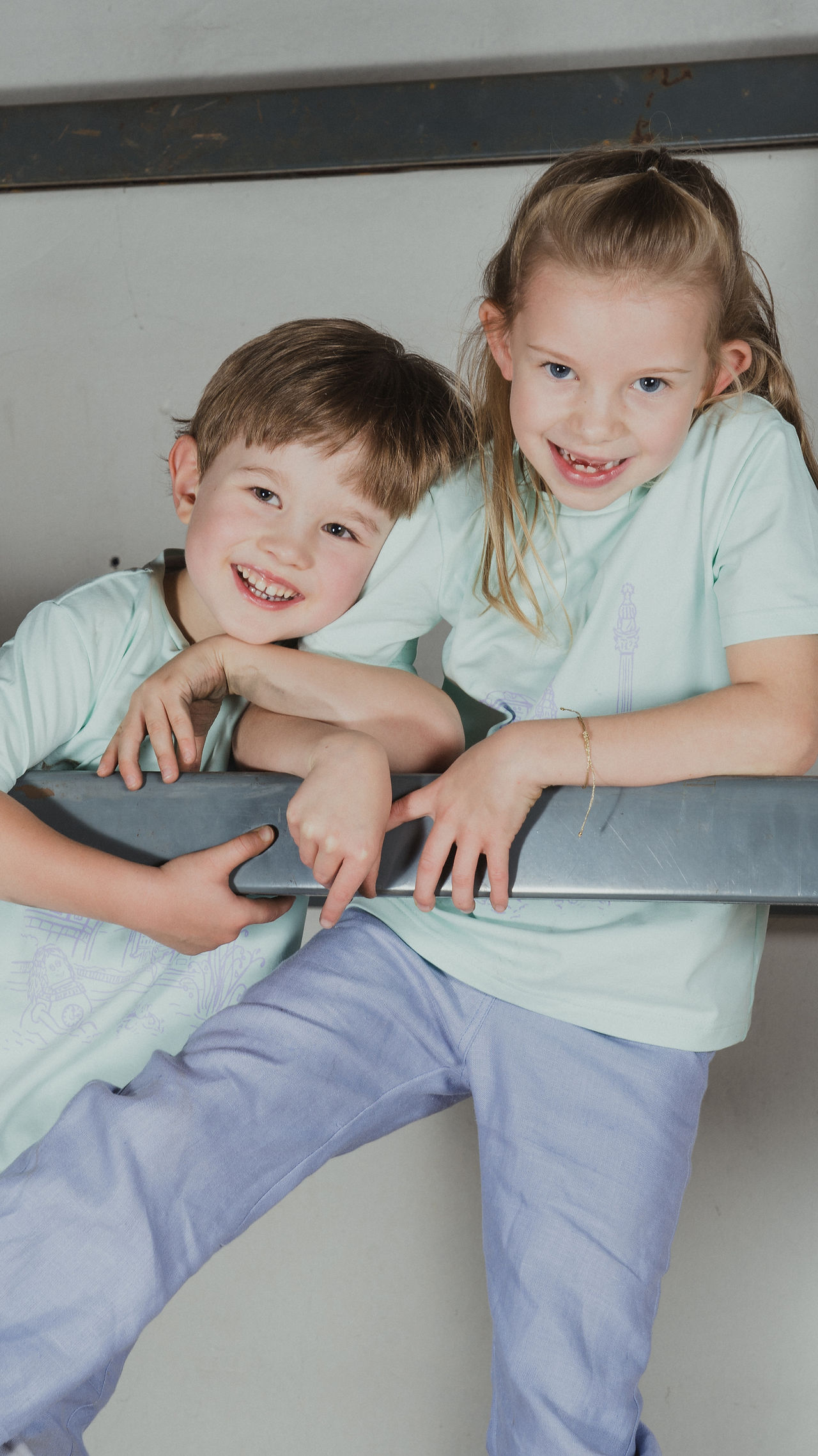 Kinder klettern am Baugerüst und lachen in Kamera