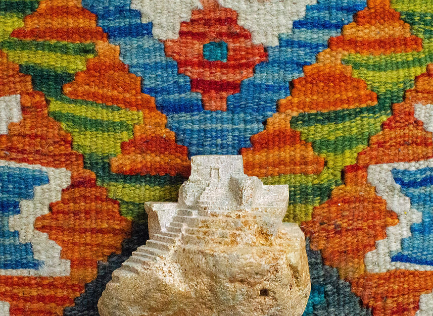 Abstraktes Haus aus Speckstein auf einem bunten Hintergrund als Ergebnis einer Kunsttherapie in Wien