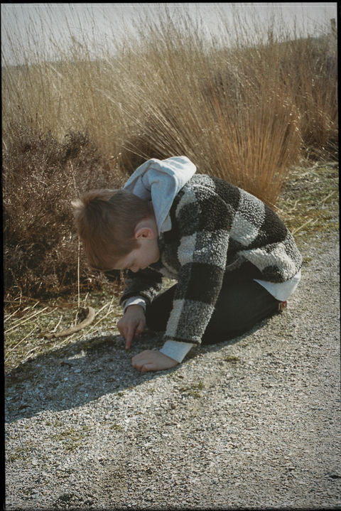 Analoge foto van een jongen die stenen zoekt