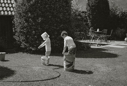 Analogue photo of two kids playing in the yard