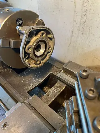 Detailansicht einer Drehmaschine beim Ausdrehen eines Aluminiumgehäuses.