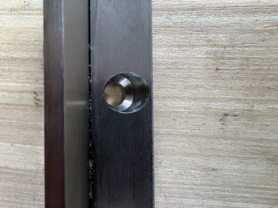 Schräg gefrästes Befestigungsloch im Fenstergitter ohne Schraube
