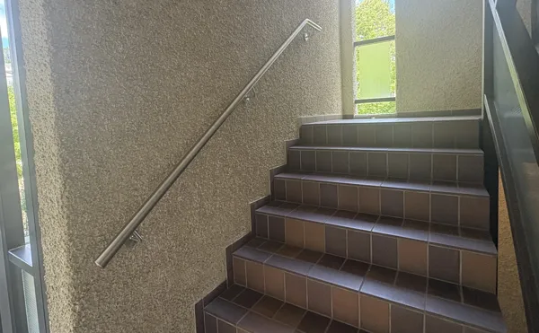 Handlauf mit Distanzhülse zur geraden Montage auf einer grob verputzten Wand