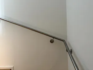 – Detailansicht einer geschweissten Ecke am Chromstahl-Handlauf im Innenbereich.