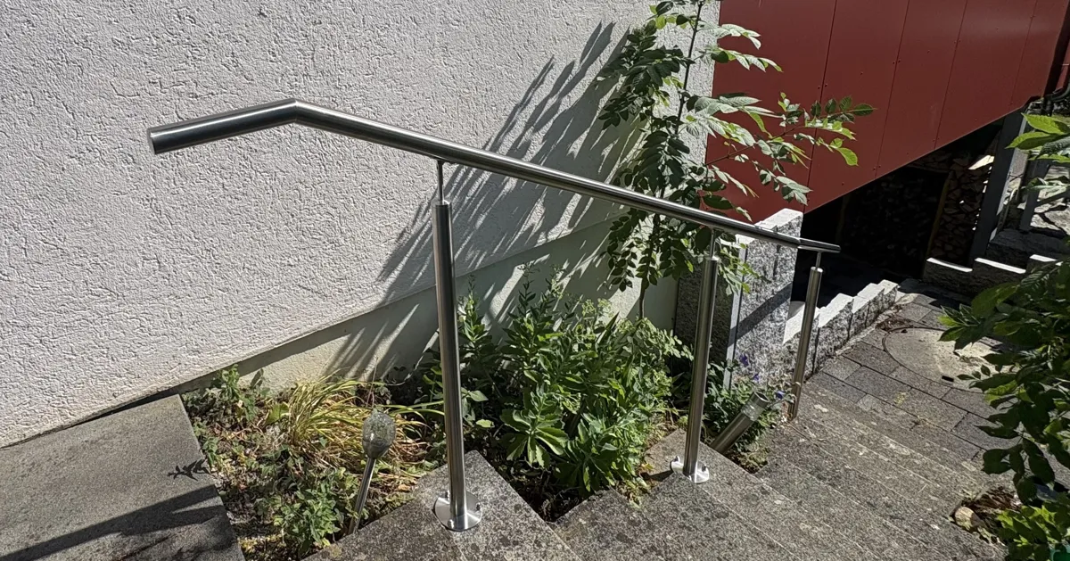 Detailansicht des abgewinkelten Handlaufverlaufs im breiter werdenden unteren Treppenbereich.