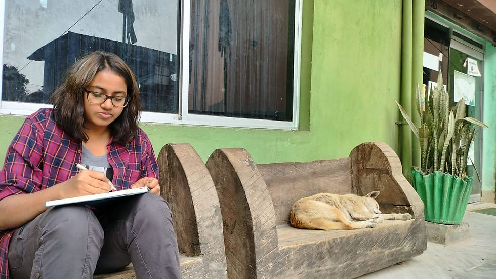 Earth Tatva Green Samaritan sketching in outdoors on wooden logs