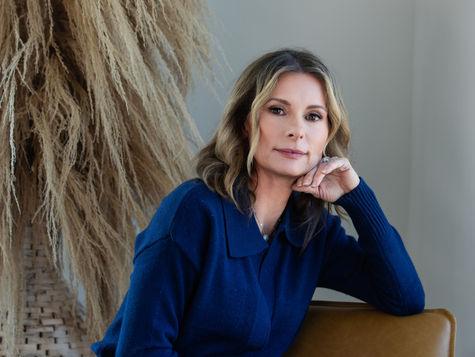 A survivor rests on a sunlit couch, journaling with a gentle, grounded expression. The warm light and soft colors reflect the inner peace, safety, and authenticity she is beginning to reclaim on her healing journey.