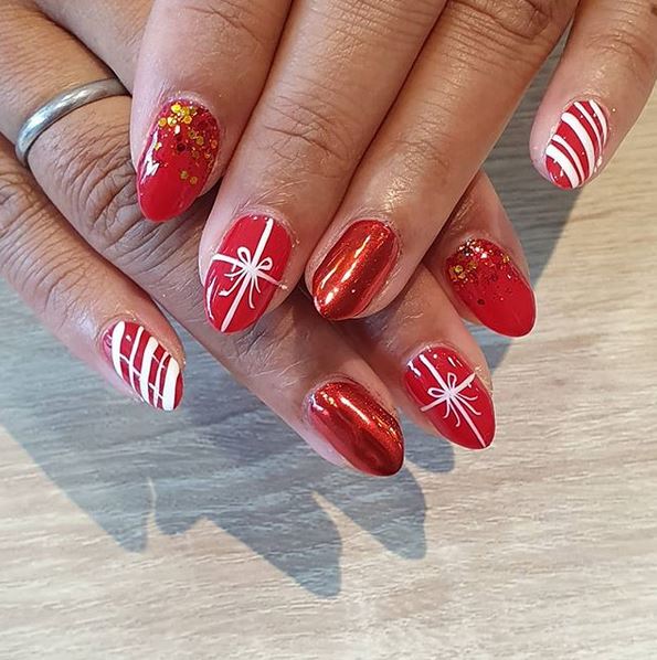 Pretty christmas nails manicure with red stripes and bows