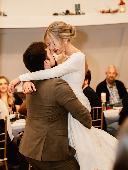 Bride and groom embrace during the wedding reception; joyful moment captured. 