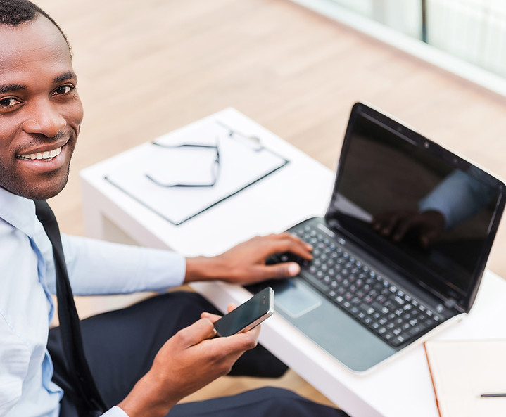 Hombre sonriente en la computadora portátil