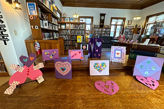 Photo of the Valentines craft cards lined up on the library desk.