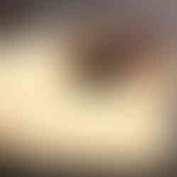 A picture of a pan of cinnamon rolls with vanilla bean cream cheese icing a spatula in the spot of 2 missing cinnamon rolls