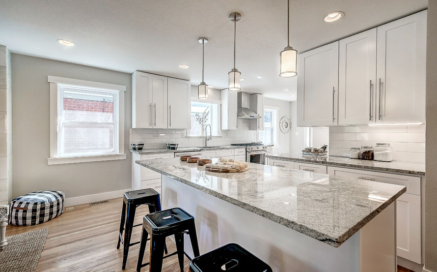 KITHCEN ISLAND WITH WHITE FURNITURE AND WOOD FLOORS