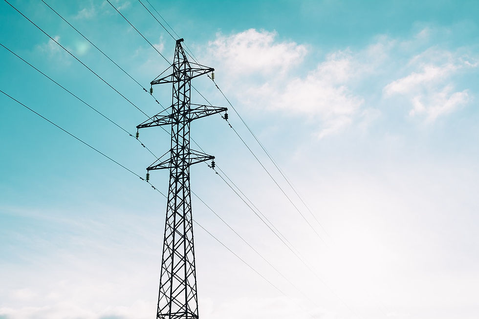 An image of a blue sky with a power transformer in the foreground.