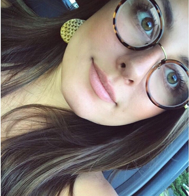Model wearing handcrafted mini leather mermaid earrings in yellow ombre
