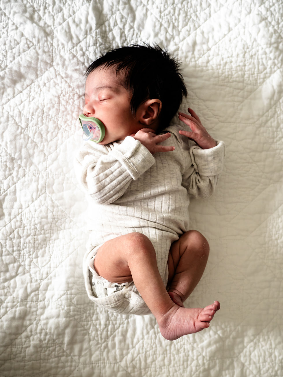 When Should Newborn Photos Be Taken - curled newborn with pacifier