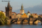 A Ponte Carlos, iluminada pela luz dourada do fim da tarde, une as margens de Praga e serve de metáfora no novo livro de Dan Brown, onde o mito do Golem e a busca da consciência se cruzam na cidade hermética.