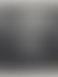 Multidão reunida à noite num protesto, com uma pessoa ao centro a erguer um telemóvel iluminado acima da cabeça.