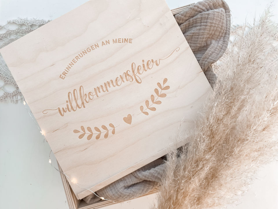 Holzkiste mit Gravur: Erinnerungen an meine Willkommensfeier neben Deko im Boho-Stil