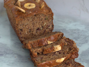 Homemade banana bread made with wholemeal flour, maple syrup, kefir and walnuts, decorated with banana chips.