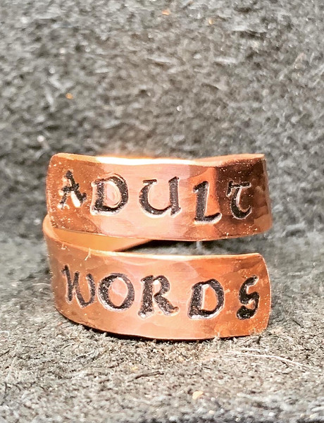 Adjustable textured copper ring with "adult words" stamped on it.