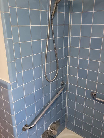 Before bathroom remodel with blue tile bathtub and shower enclosure in Eagleville PA
