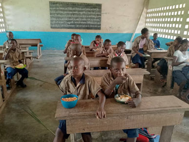Enfants mangeant à l’école de Linzolo grâce à la cantine scolaire – amélioration de l’assiduité et des conditions d’apprentissage soutenue par Kimvuka Mvuala Tatu (KMT)