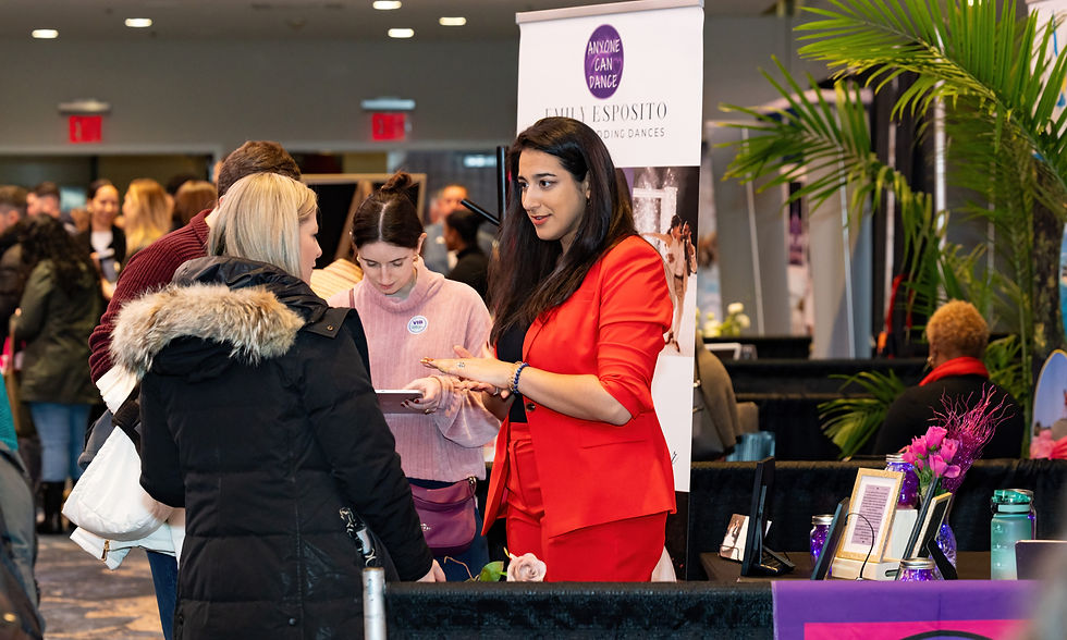 Wedding vendor talking to engaged brides at a wedding show.