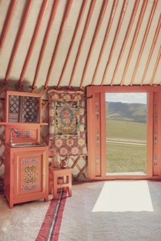 Interior of a yurt with open door showing scenic view