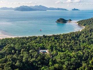 Aerial view of Datai Langkawi resort nestled in lush rainforest, overlooking tranquil ocean