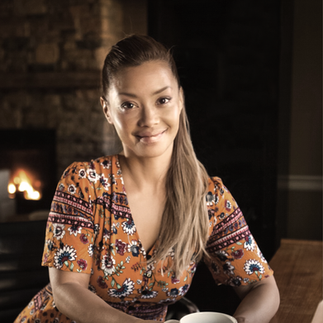 Smiling woman in orange dress near fireplace