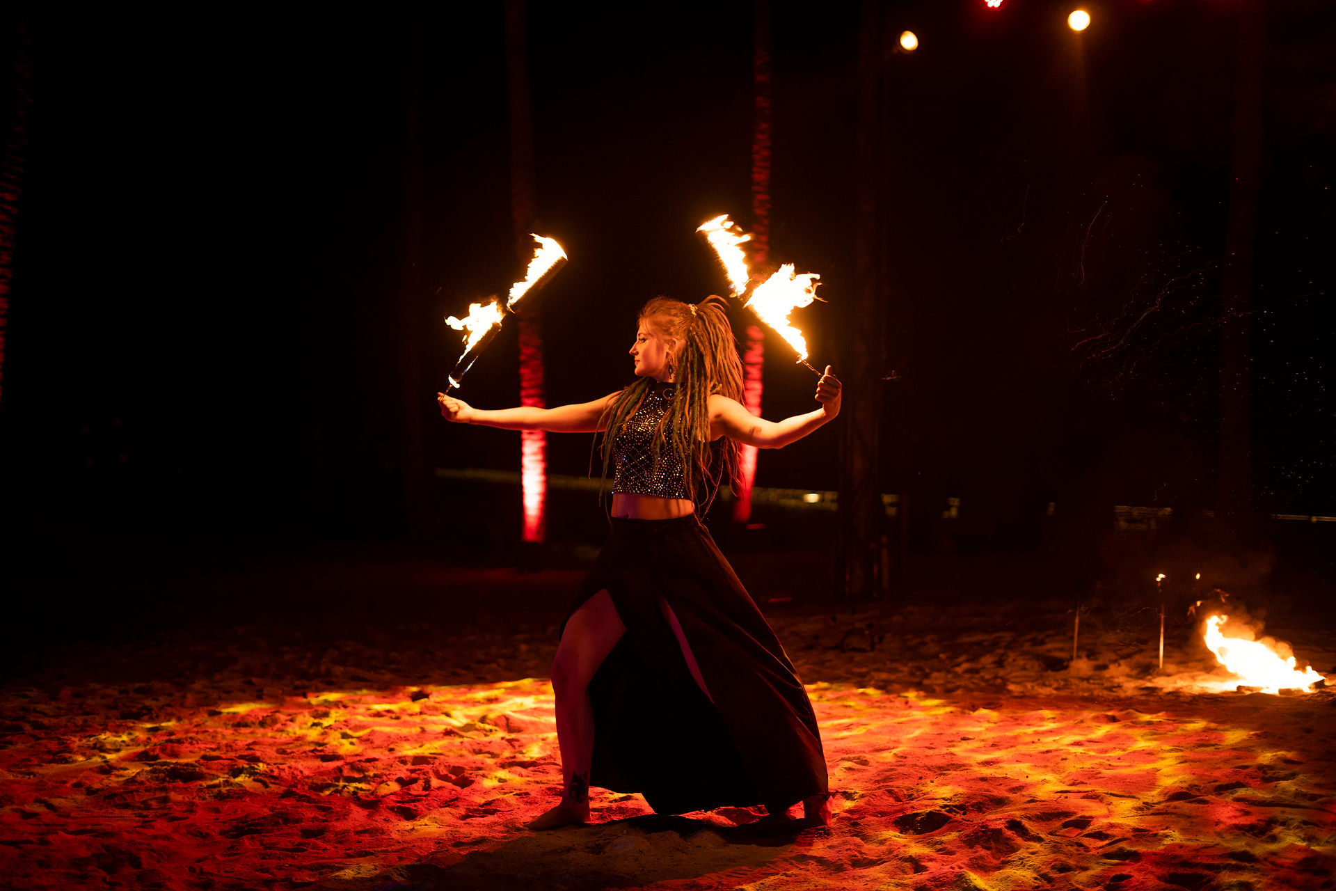 Fire dancer twirling flames at night