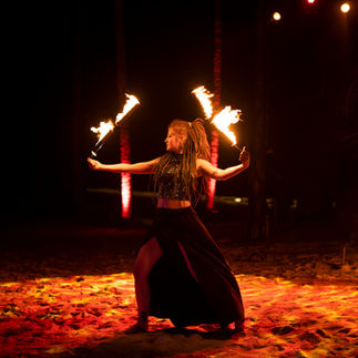 Fire dancer twirling flames at night