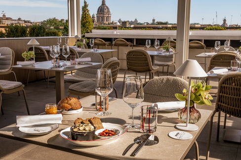 Rooftop restaurant with Rome view, tables set for lunch