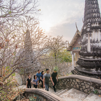 Tourists ascend stone steps toward ancient temple