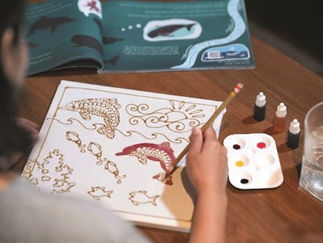 Person painting batik dolphins