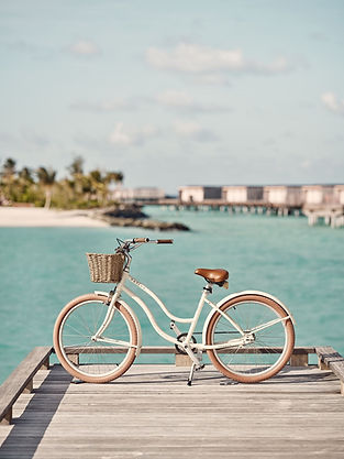 Classic bicycle at Patina Maldives, Fari Islabds, with the lagoon and overwater villas in the background
