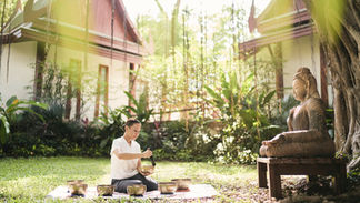 Woman playing singing bowls outdoors