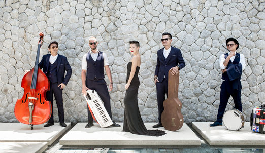 Band posing for photo with singer