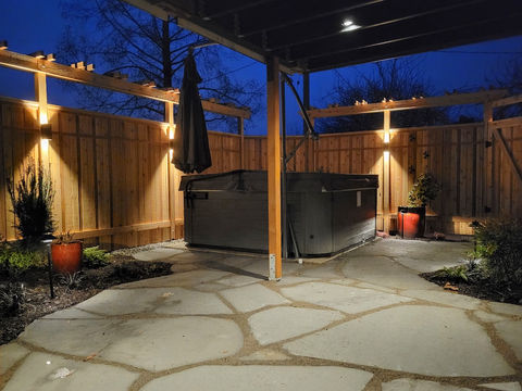 Dramatic lighting along a fence warms the entire back yard