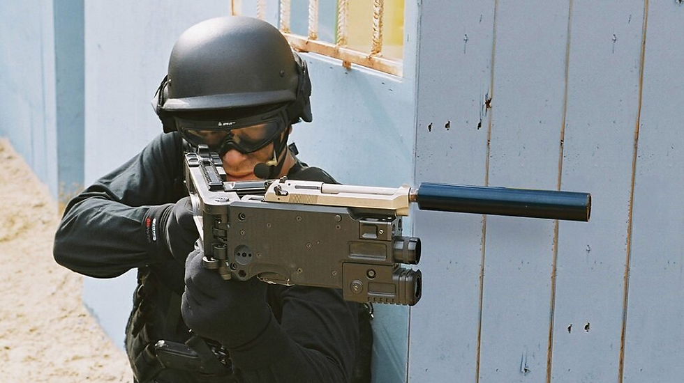 Tactical officer in black gear aims a suppressed rifle in a narrow blue hallway, tense and focused.