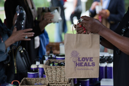 Thistle Farms shopping bag changing hands