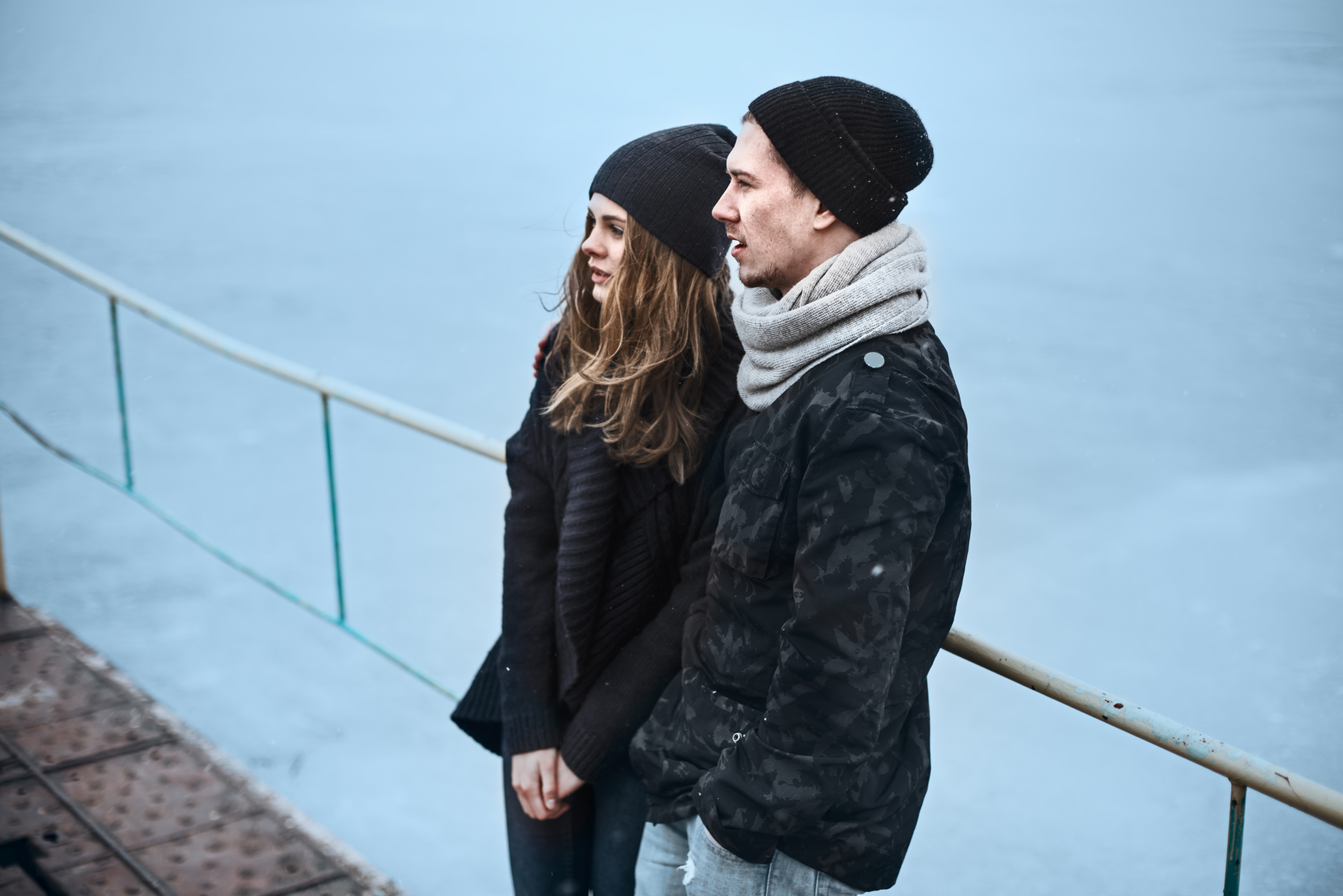 A couple on a boat, gazing at the water.