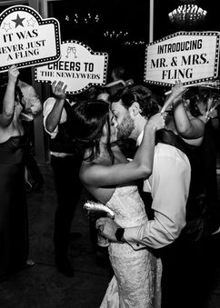 Couple celebrating end of the night at their reception with signs featuring the new Mr and Mrs, at Seventy Five Venue