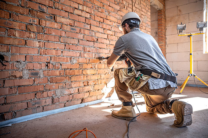 handyman-at-a-construction-site-in-the-process-of-drilling-a-wall-with-a-perforator(1).jpg
