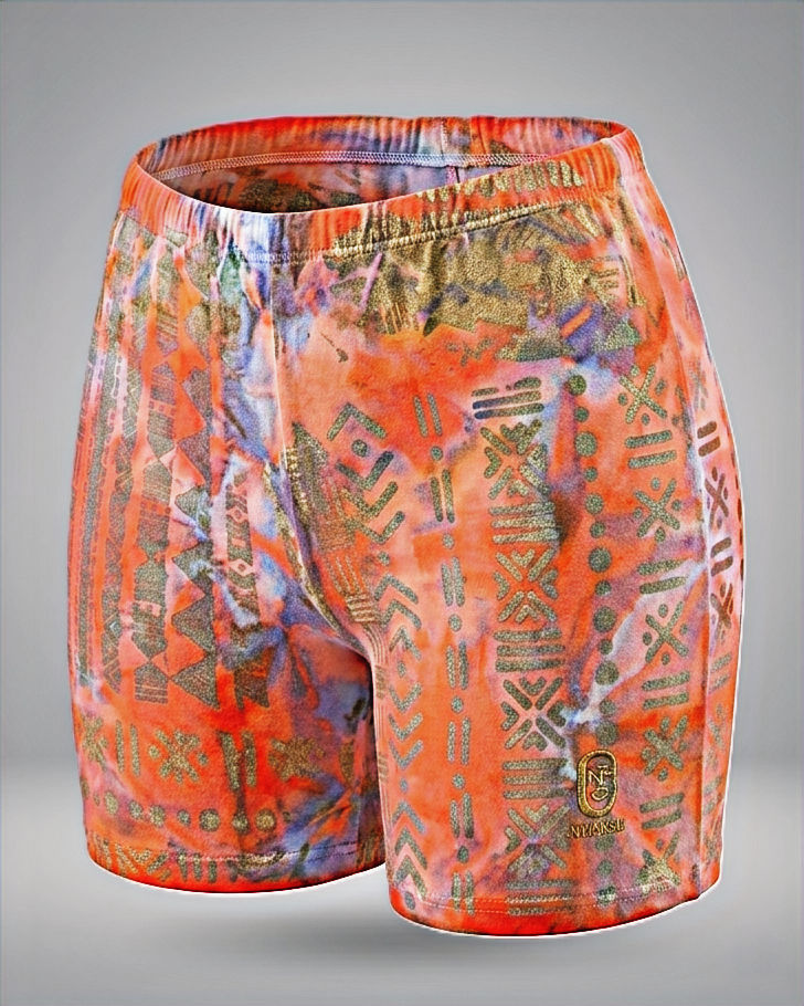 Highcycled red Adire tie-dye biker shorts featuring metallic silver symbols inspired by Bogolan. Available at Esteta Atelier