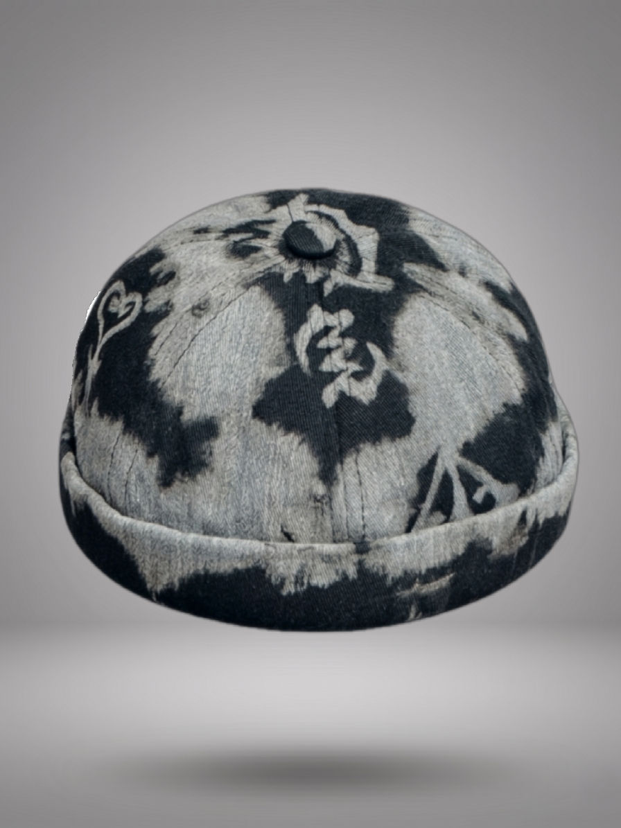 Brimless grey and black Adire hand-dyed Miki hat featuring a traditional Adinkra symbol, shown from multiple angles.